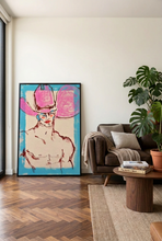 Load image into Gallery viewer, A large framed abstract portrait print featuring a shirtless figure with a pink hat, leaning against an off white wall in a styled living room with a brown sofa and a wood floor.