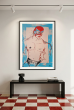 Load image into Gallery viewer, El Luchador... by IsaLu Ishii – framed art print featuring a shirtless male figure wearing a red and blue mask, displayed on a white wall above a black console table in a modern interior.
