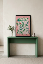 Load image into Gallery viewer, Perfectly Imperfect... Torero!! by IsaLu Ishii - an art print, framed featuring an artistic, slightly abstract depiction of a torero in green, pink and off-white. Displayed on top of a green console table. 

